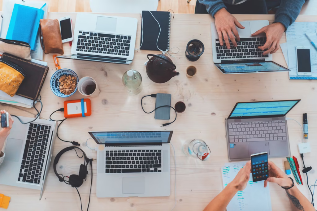 View from above of a desk with laptops and mobile devices